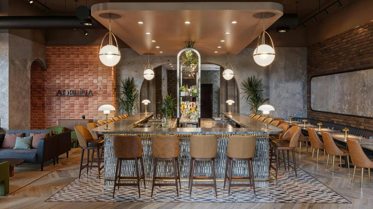 Chic modern bar with stylish seating and hanging lights, perfect for social gatherings.